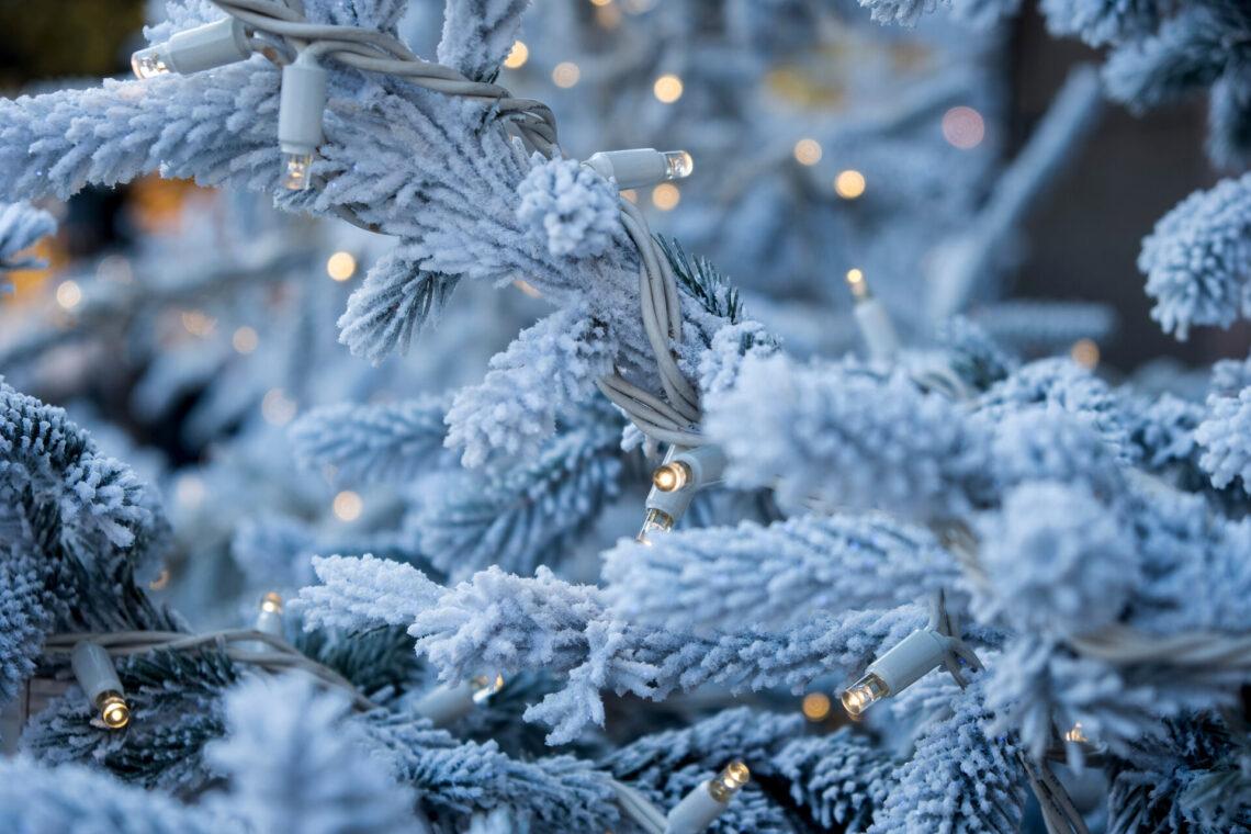 Weißer künstlicher Weihnachtsbaum mit Lichterkette.